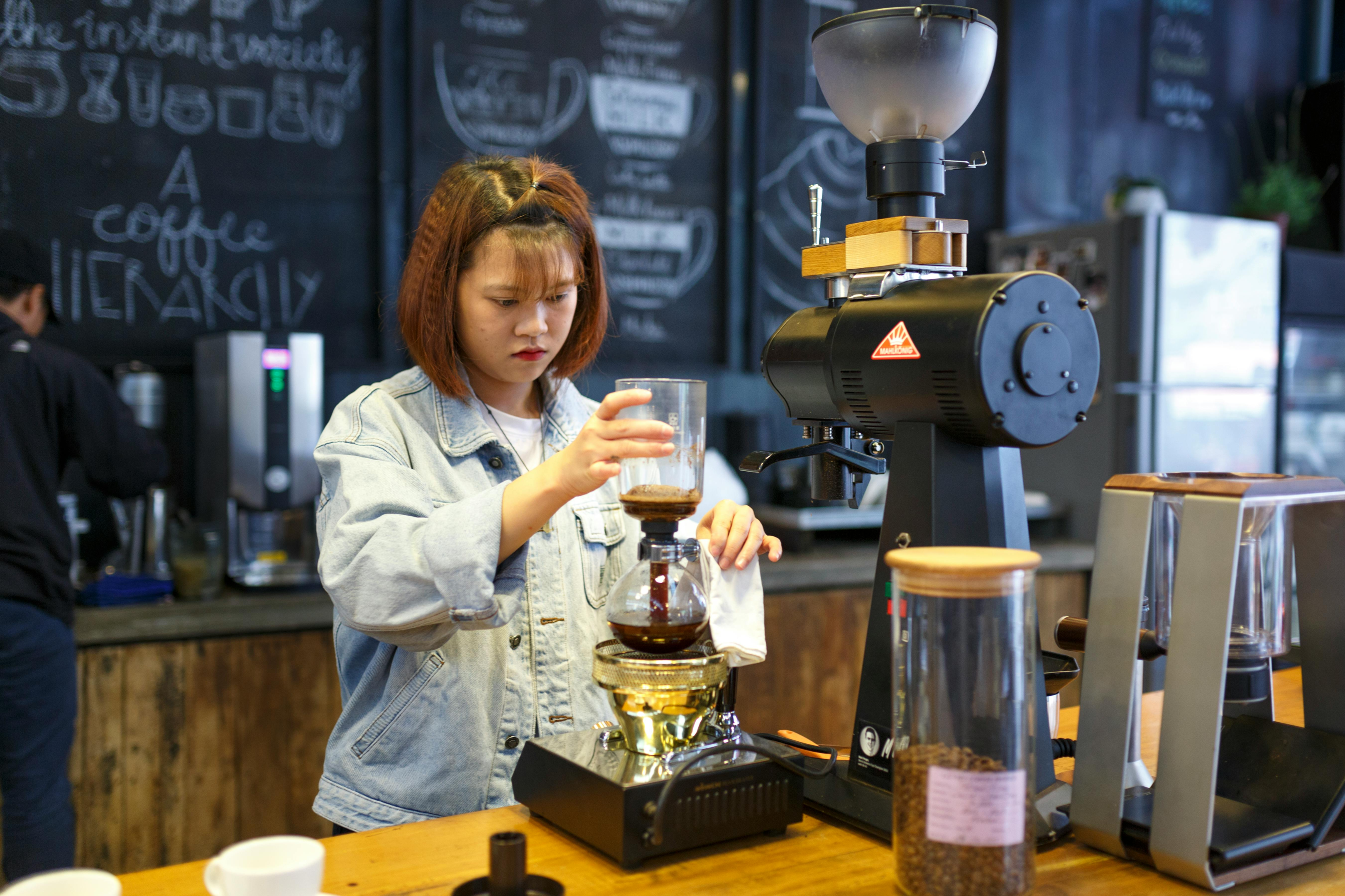 woman making coffee in a cafe