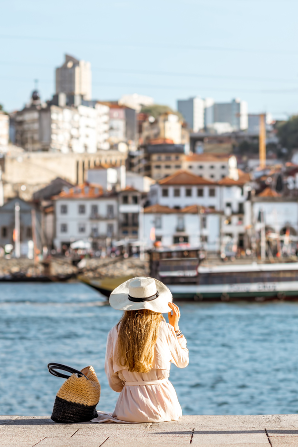 woman sitting on a dock with her bag and hat as the final image for our article on ESG scores