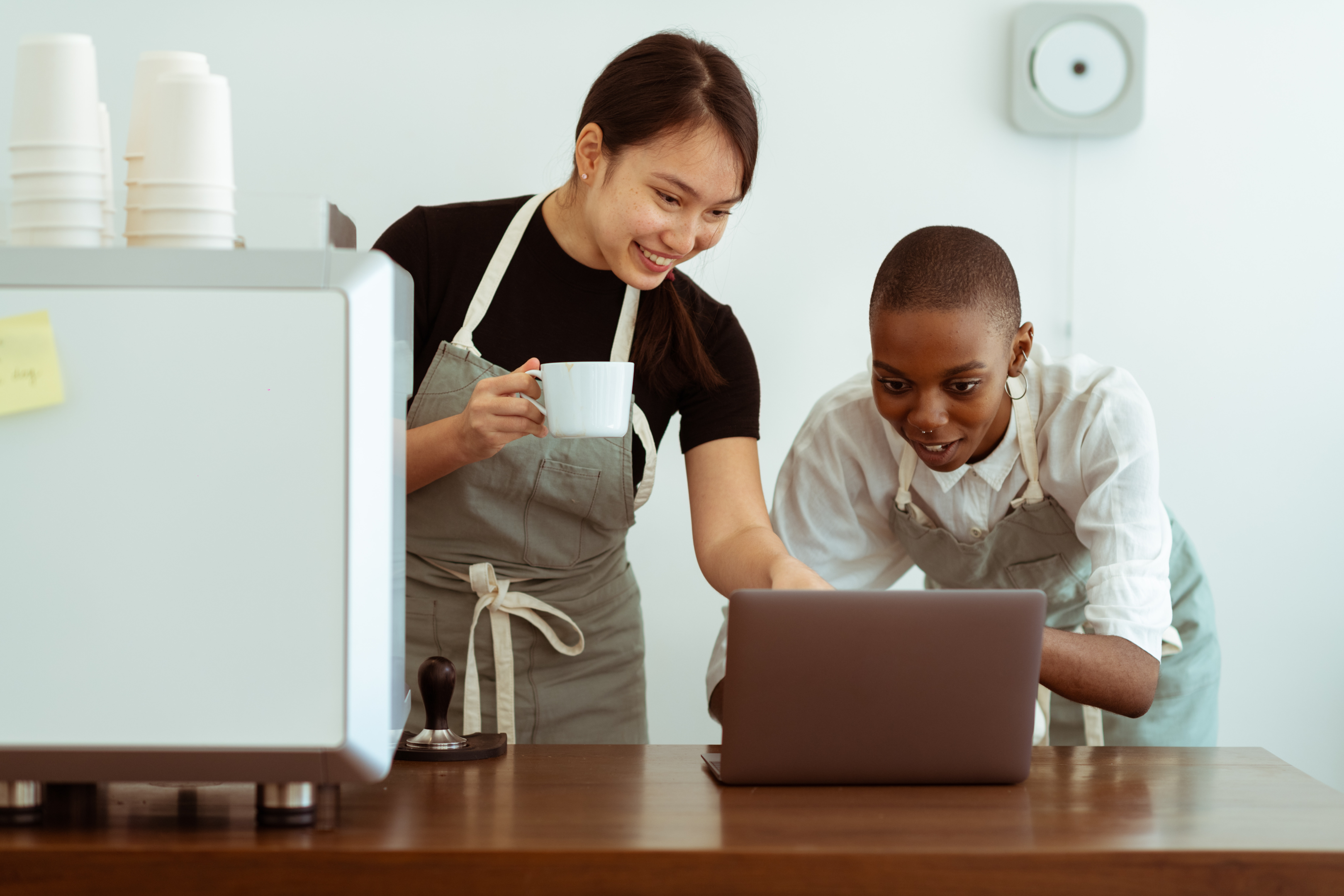 Two members of staff checking their laptop. 