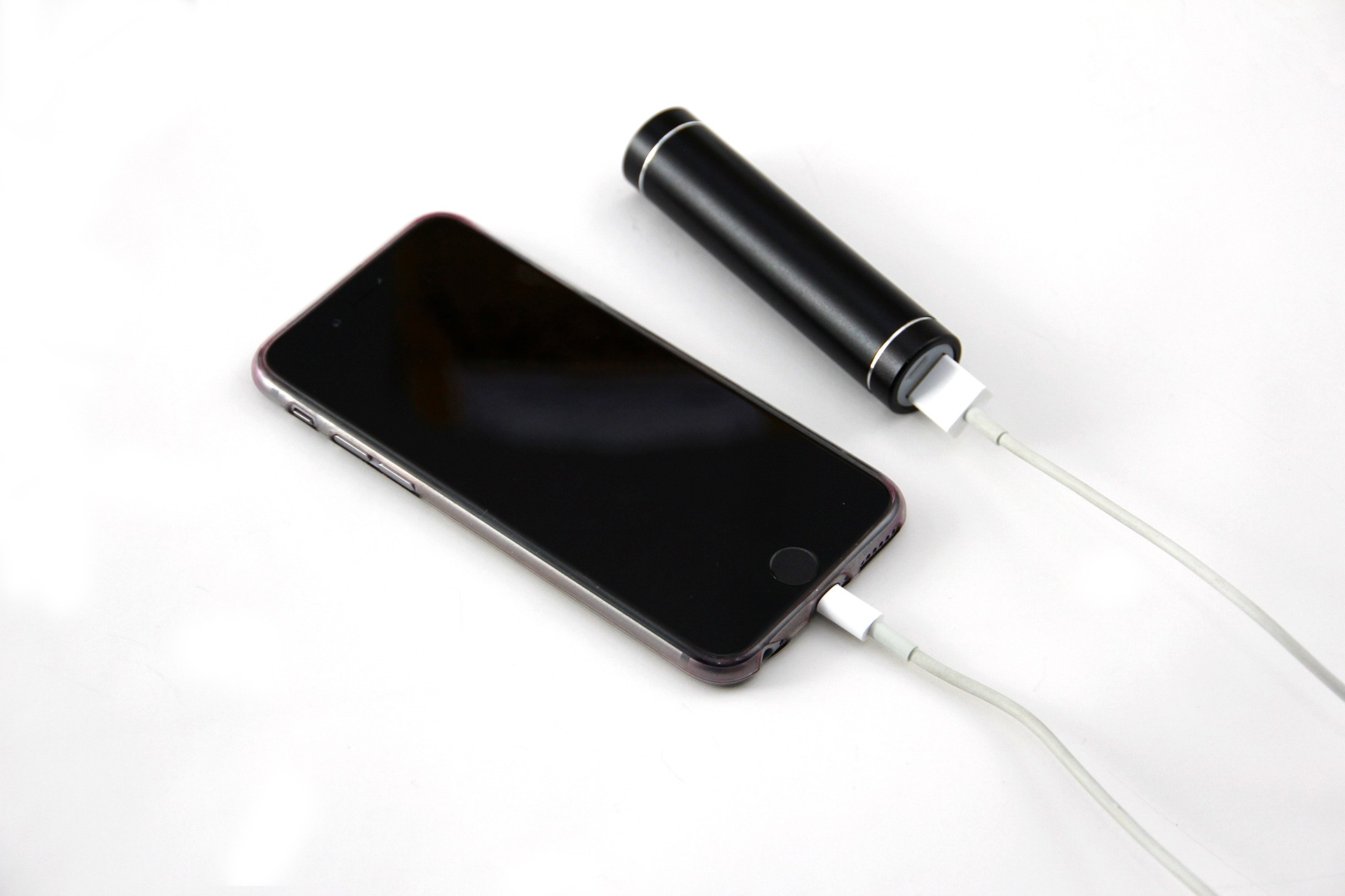 A smart phone charging from a portable battery.