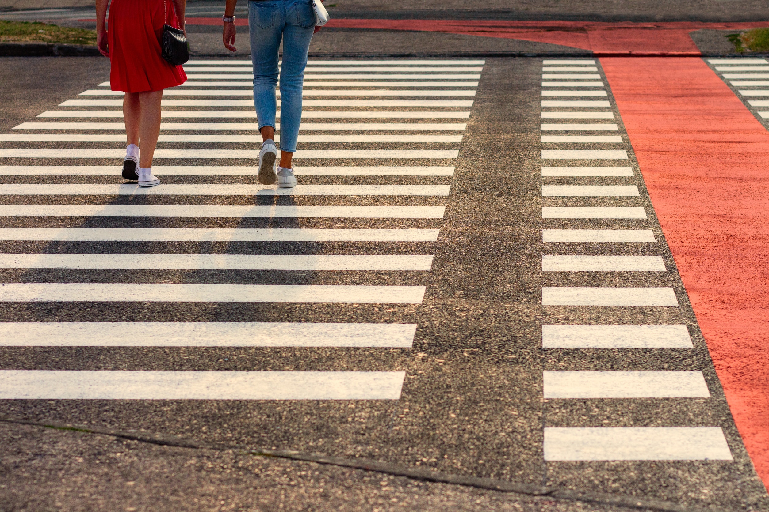 Two women walking across a zebra crossing