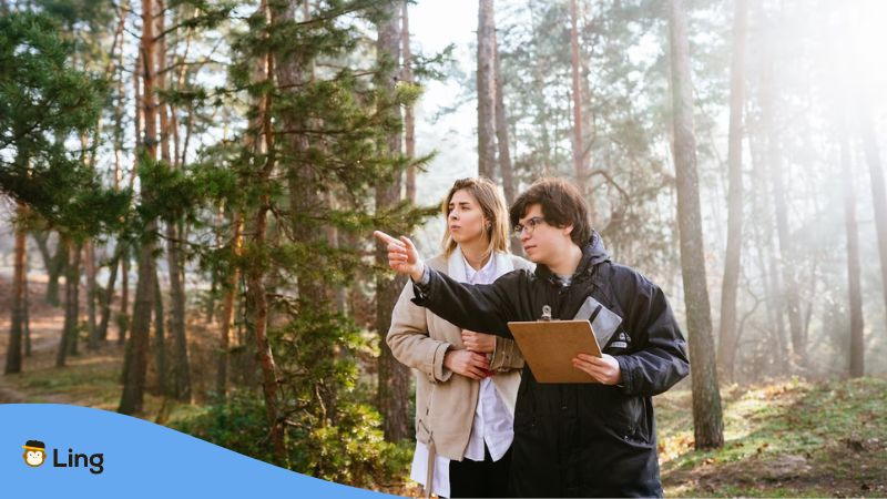 A photo of two researchers inside a forest stduying plants in Lithuanian.