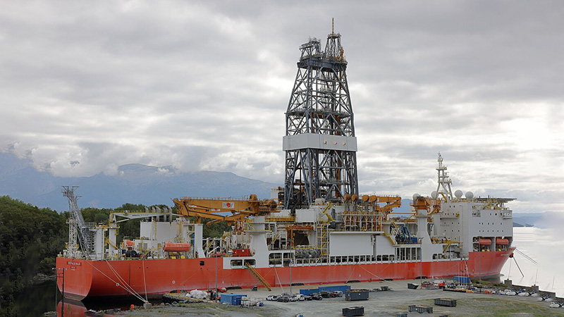 Massive Drillship Docked at a River Bank