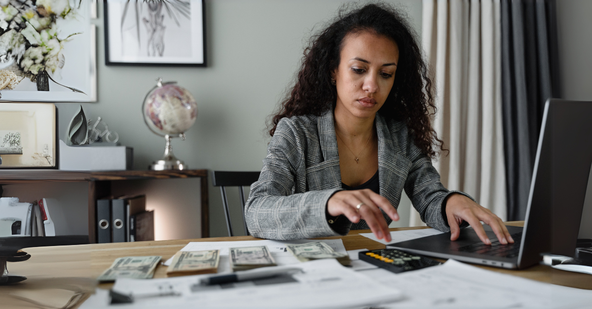 Woman working on finances with cash and calculator; "Introduction to Pass-Through Entities" concept illustration.