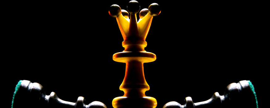 Die Schachfigur König mit zwei umgeworfenen Bauern als Sinnbild für Autorität