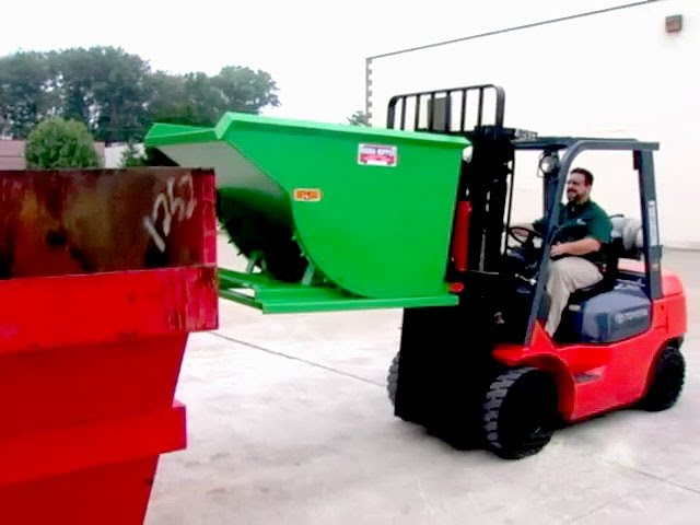 A forklift lifting a self-dumping hopper filled with materials