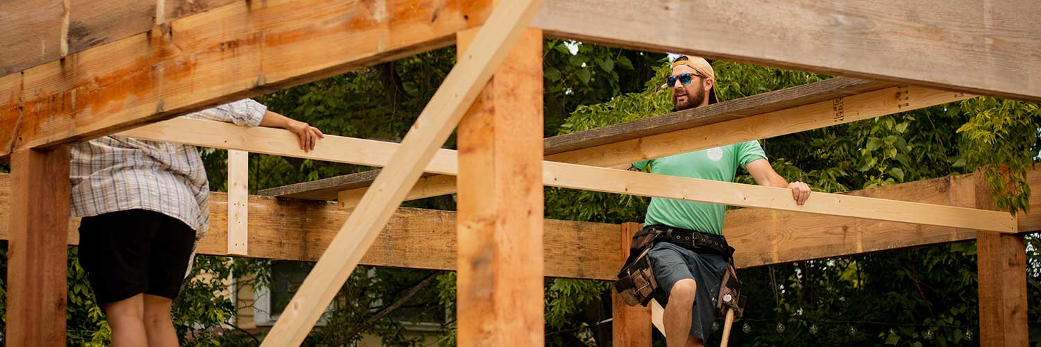 A plumber coordinating with other trades during the rough-in plumbing phase of a new construction project