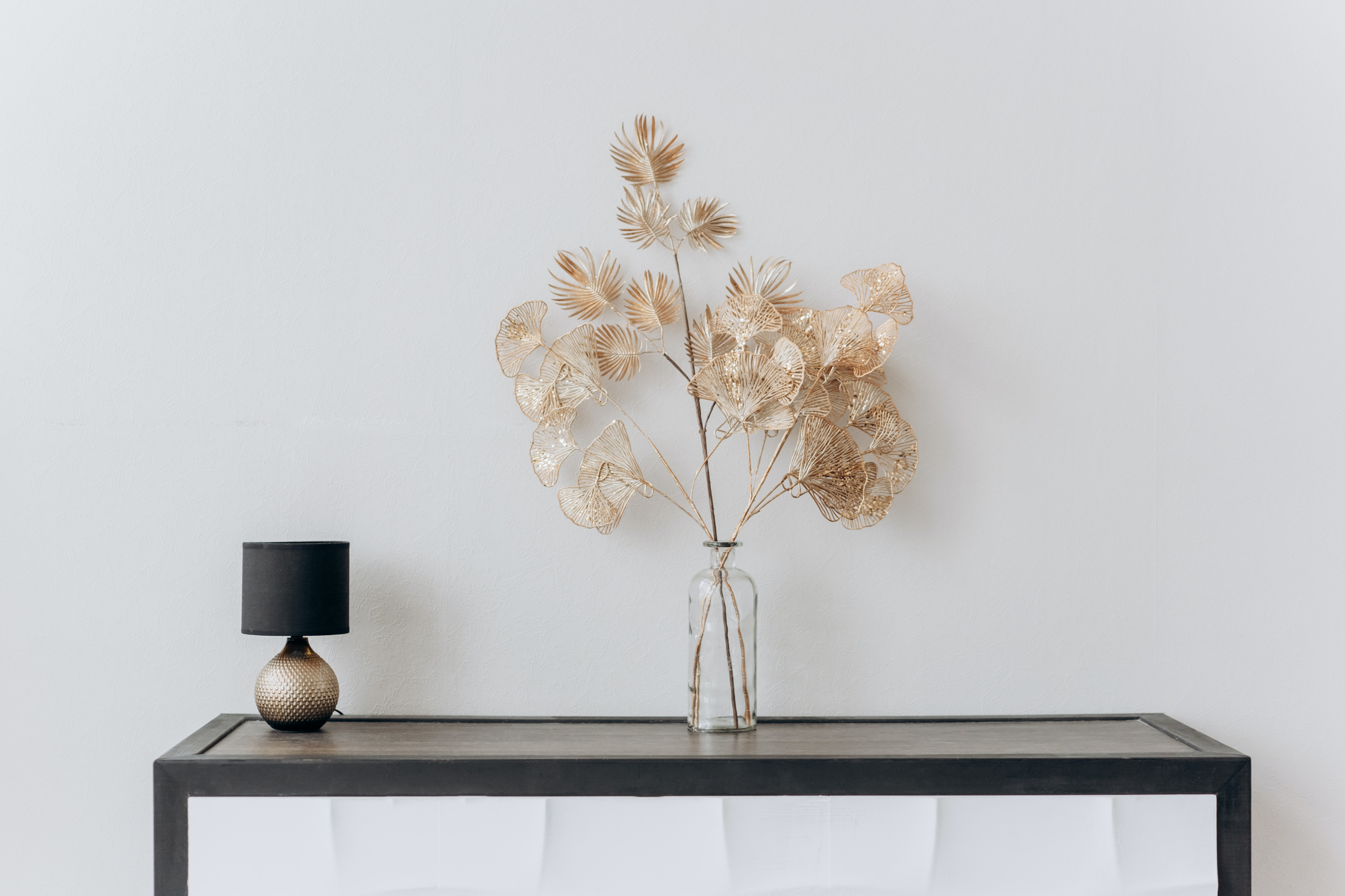 decorative flower vase and lamp on black console table