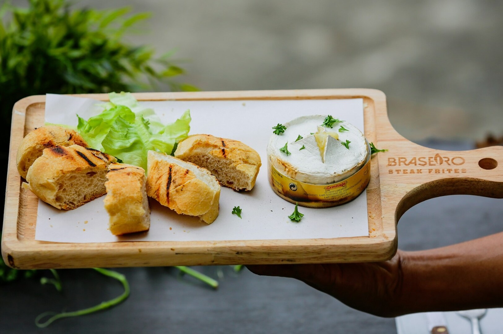 A wooden tray features an assortment of bread and salad, highlighting heritage dishes shared on social media platforms.