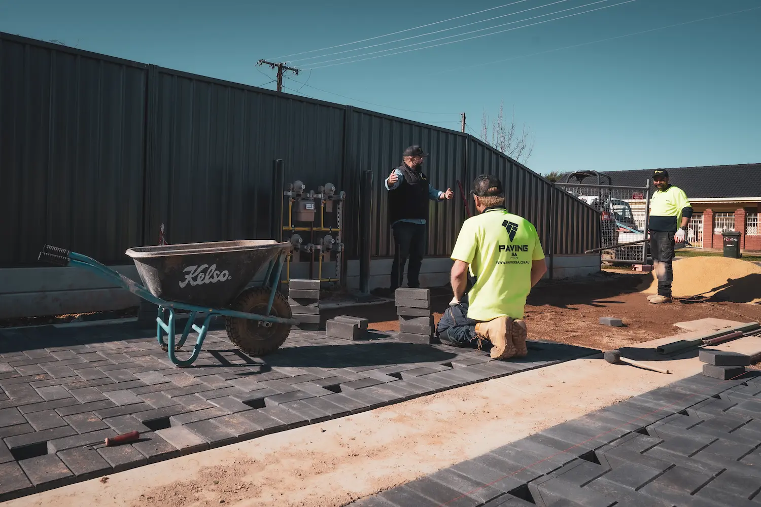 A person troubleshooting a common issue with pavers