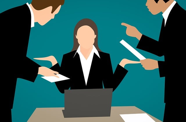 A cartoon rendering of an angry businesswoman arguing with two male coworkers at her workstation. 