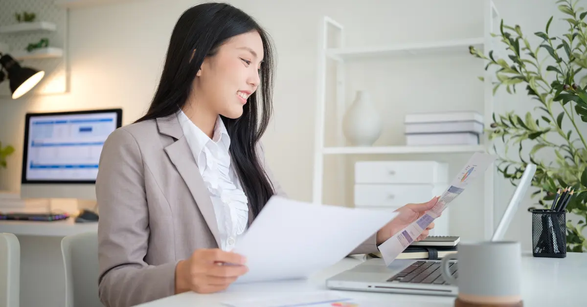 OnlyFans creator reviewing LLC paperwork while researching how are LLCs taxed for her business.