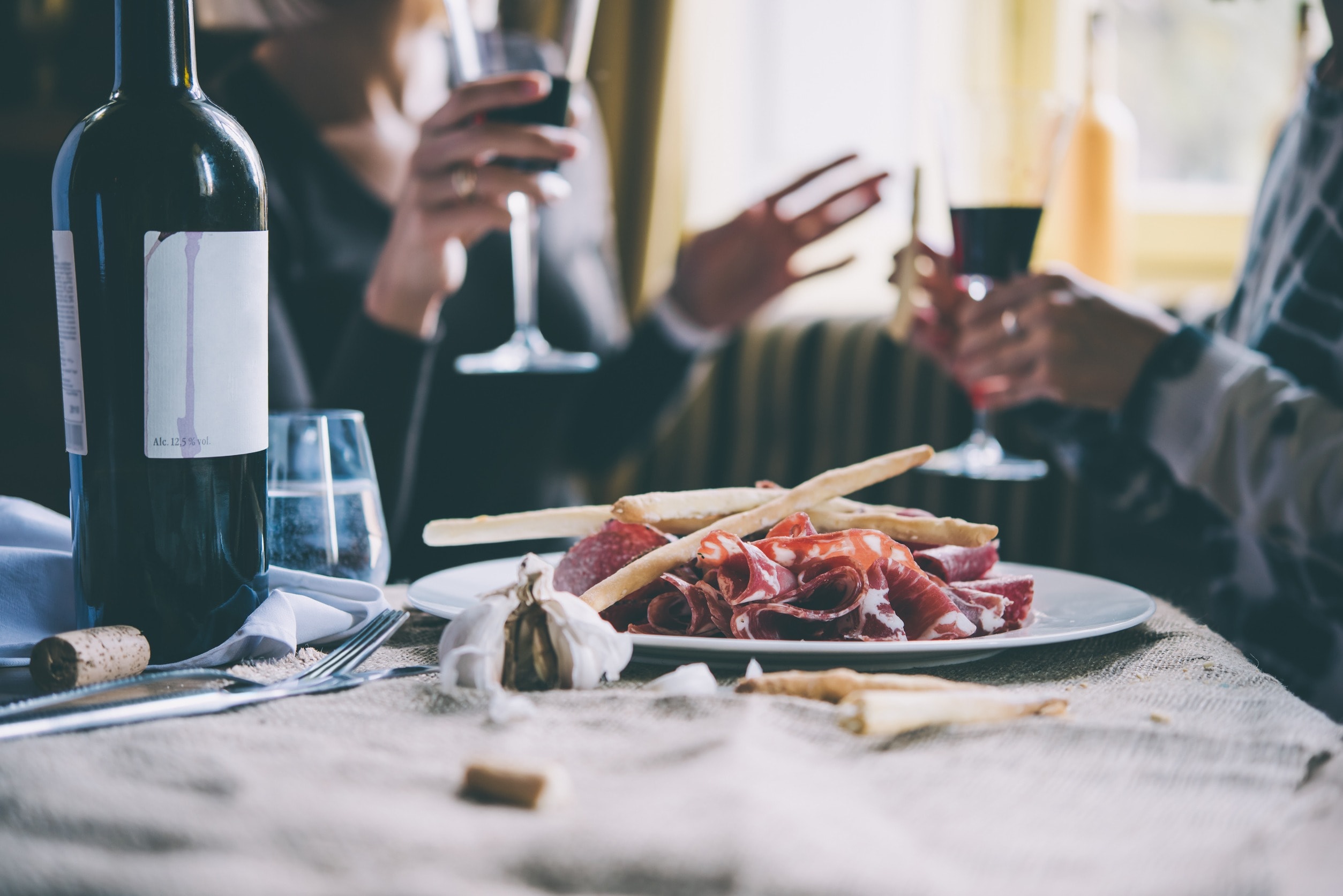 Friends drinking wine and eating food at a bar