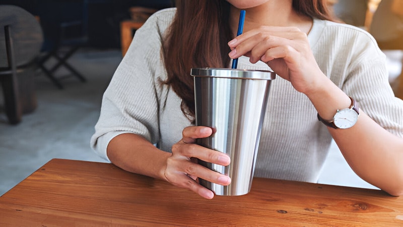 woman drinking coffee in stainless steel cup