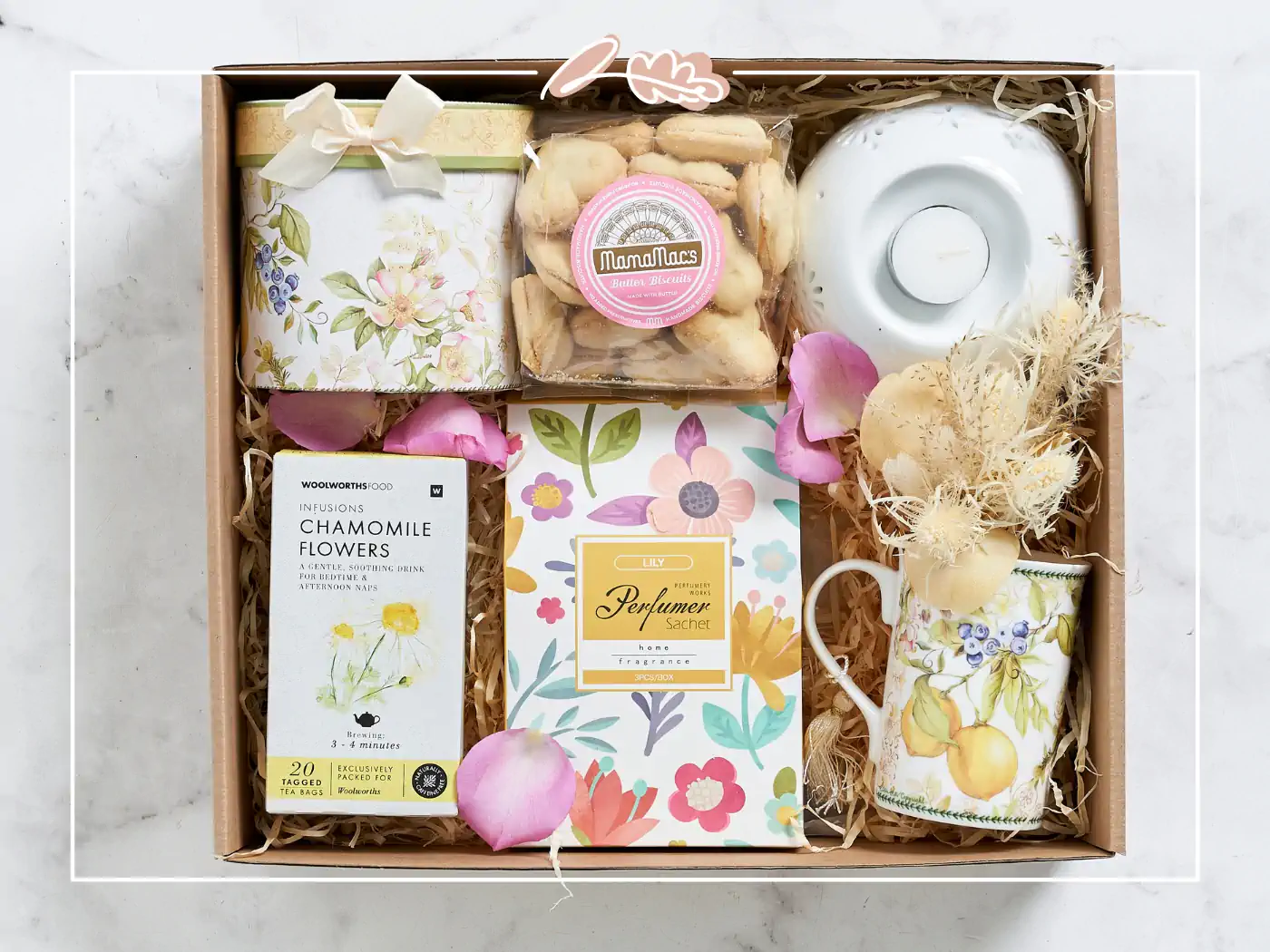 A beautifully curated gift box featuring chamomile tea, cookies, a floral mug, and other delightful items. Fabulous Flowers and Gifts.