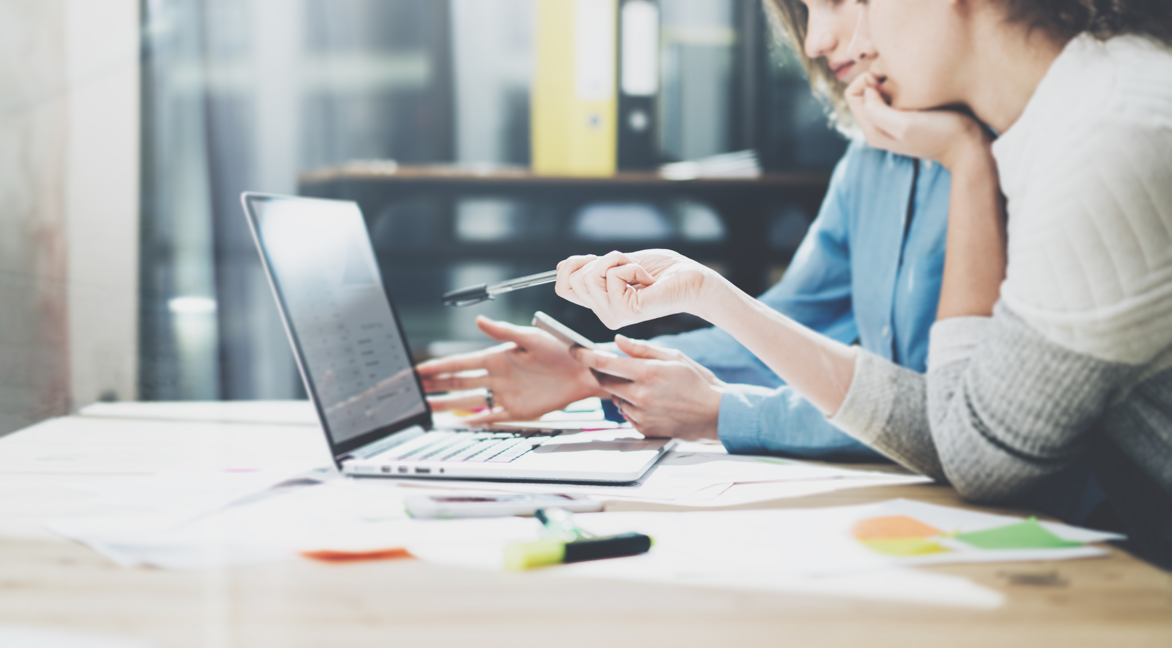 two women brain storm a marketing strategy on a laptop