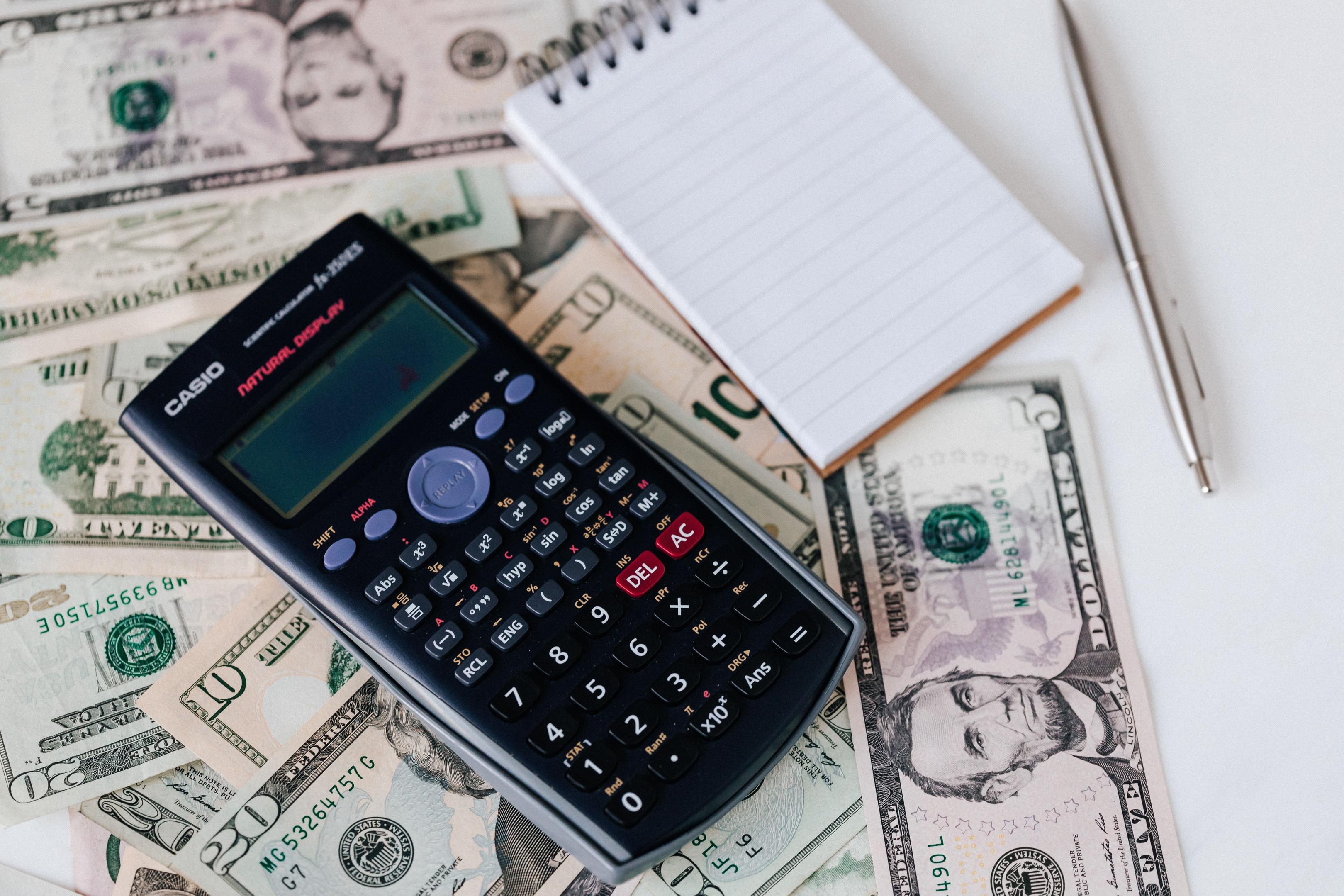 A restaurant owner sits at a desk with a laptop and calculator, reviewing financial documents that cover food costs, labor costs, and other operating expenses for a profitable restaurant.