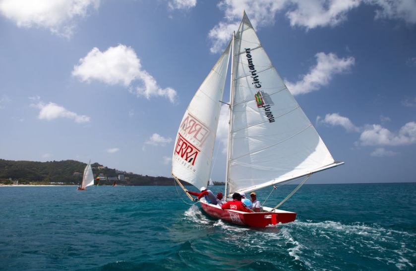 red sailing boat going out to sea