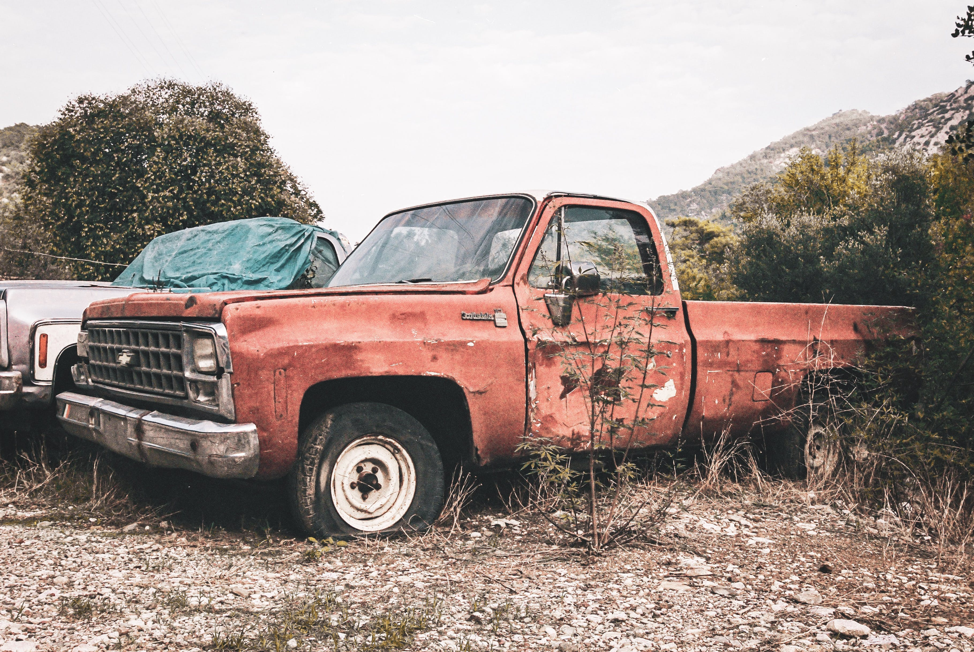 A junk car with scrap metal prices in the background