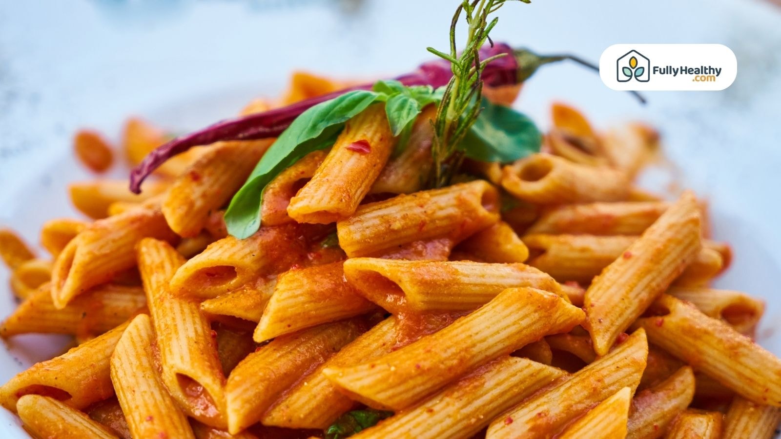 Penne pasta with tomato sauce and basil leaves