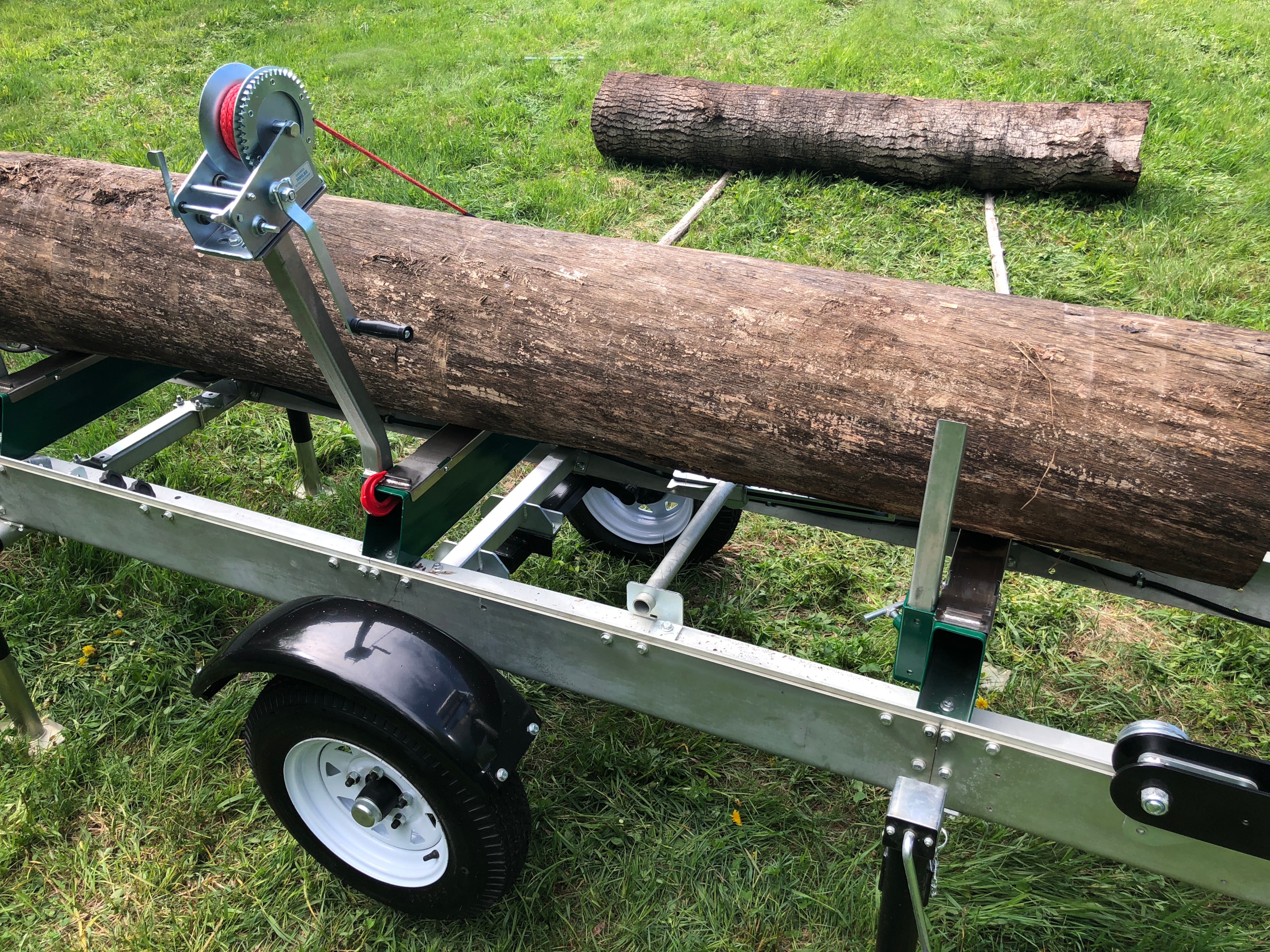 A log sitting on the track of a Woodland Mills portable sawmill. 