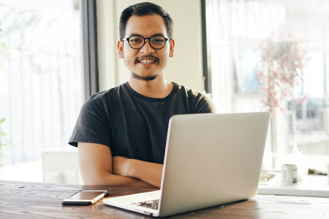 Filipino remote worker sitting confidently in front of a laptop for a virtual hiring process