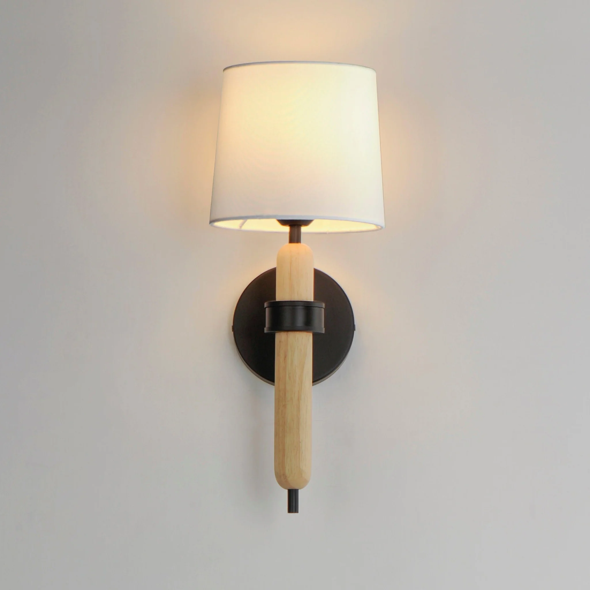 Bozeman 1-Light Sconce by Maxim Lighting with white oak wood accents, matte black frame, and linen shade, perfect for modern or rustic interiors.