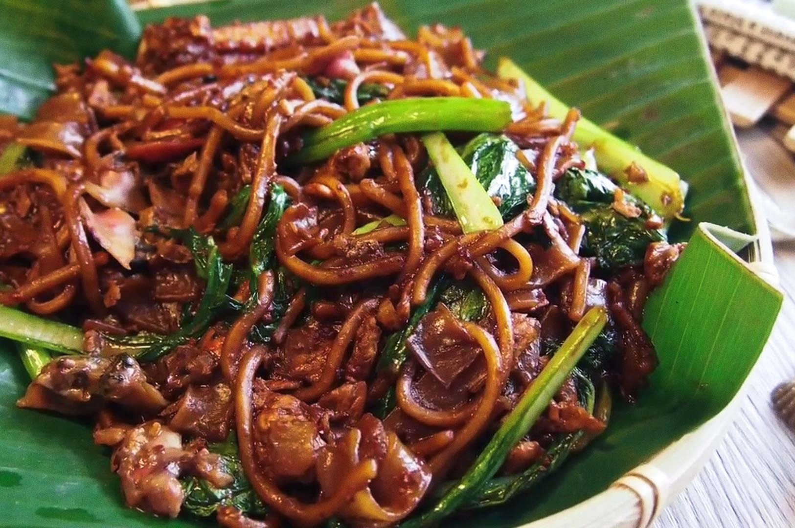 Char kway teow served on a banana leaf.