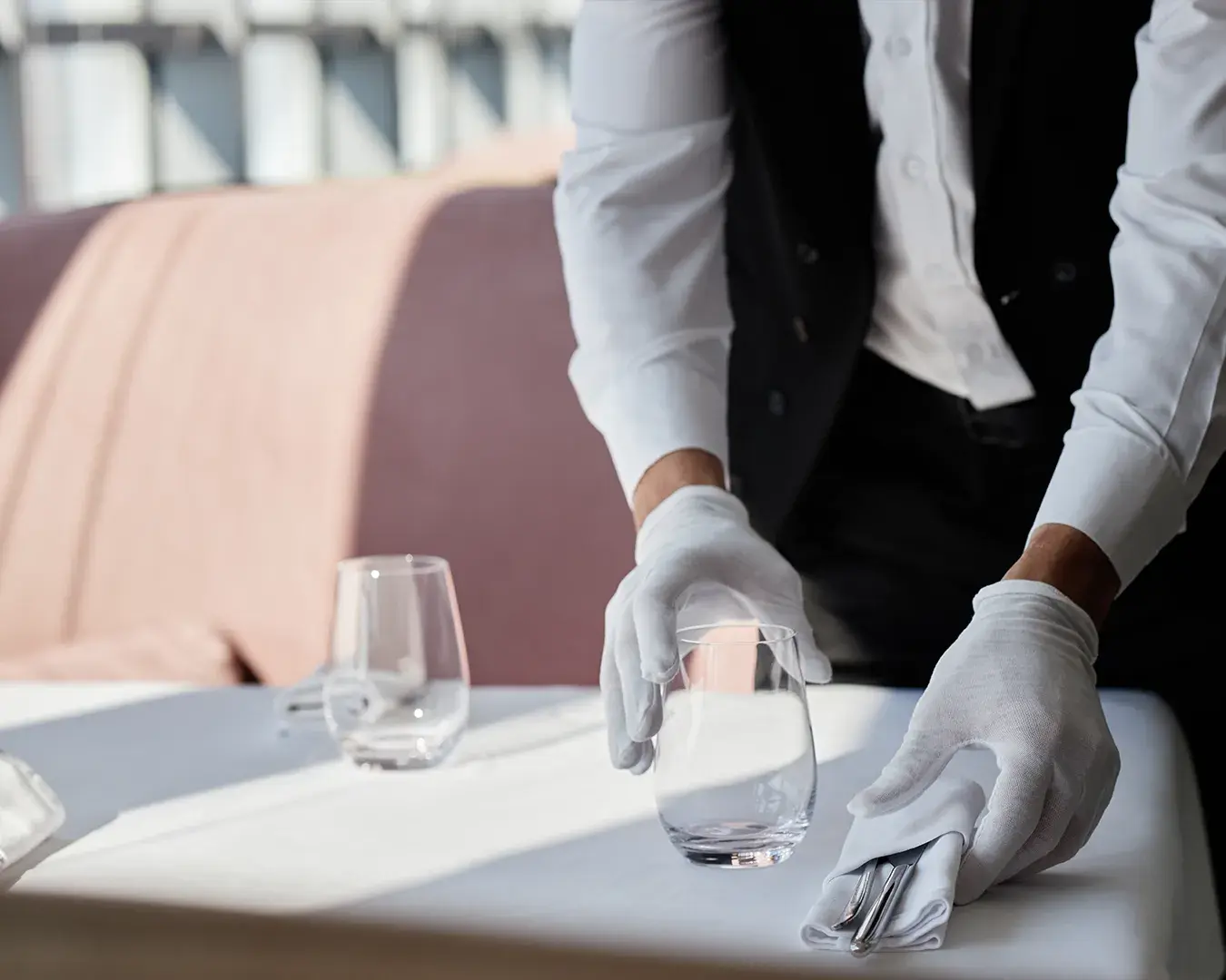 Restaurant server providing attentive table service in a fine dining setting