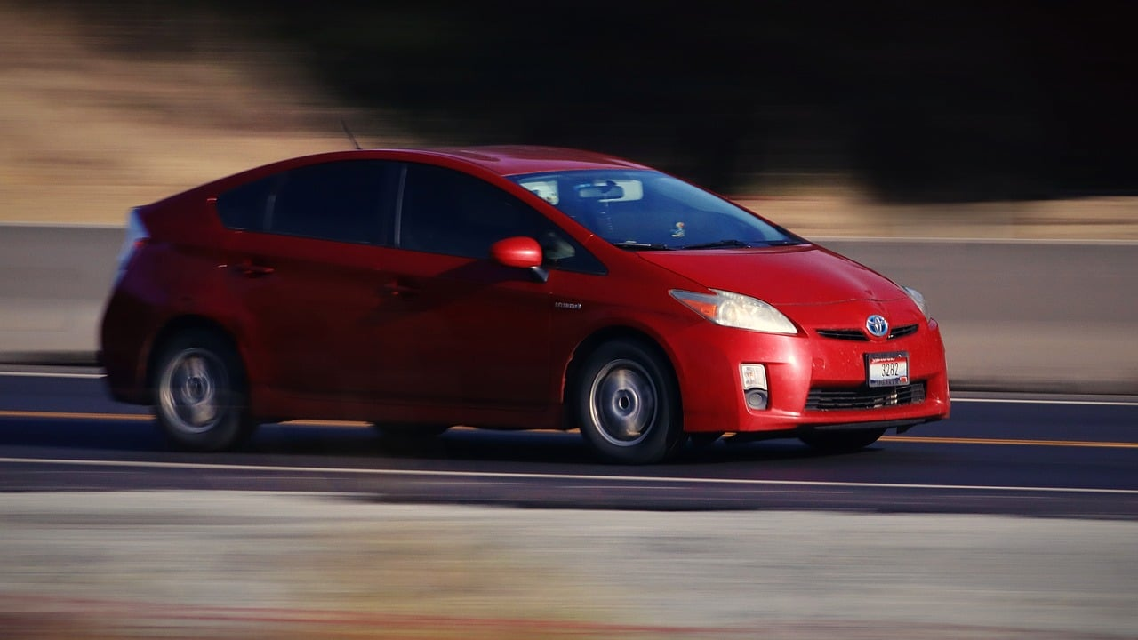 a red Prius car on the road