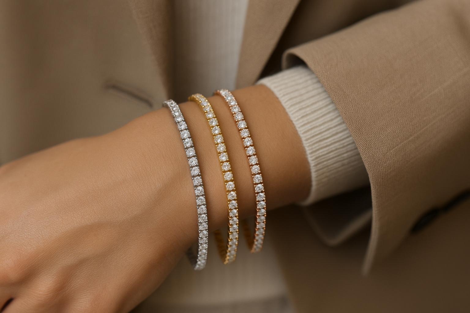 Stilingos merginos ranka papuošta trimis tennis apyrankėmis su deimantais – iš balto, geltono ir raudono (rožinio) aukso, matosi elegantiški drabužių fragmentai