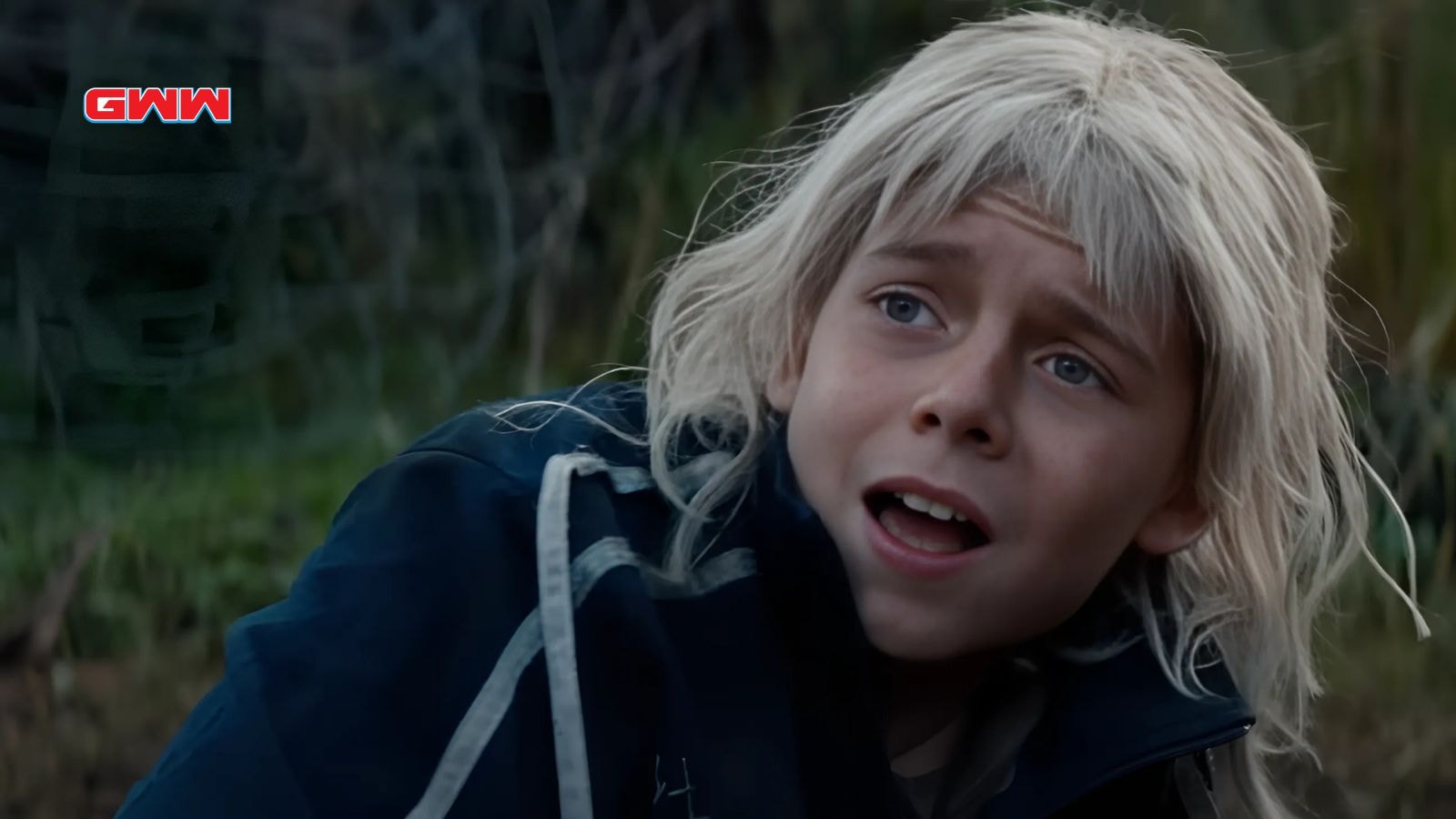 Alfie Williams as Spike lying on grass with shocked expression mid-escape