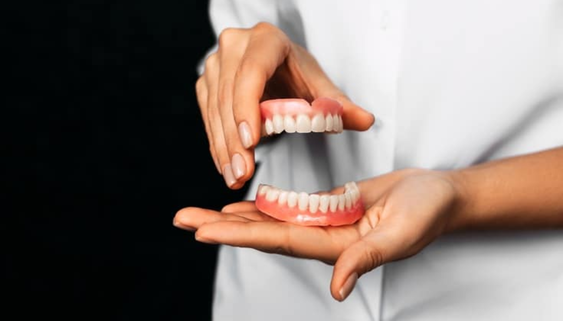 Falske tenner som ser ekte ut – Moderne løsninger for et naturlig smil 18 "Tannlege holder et sett med avtakbare proteser i hendene under en demonstrasjon."