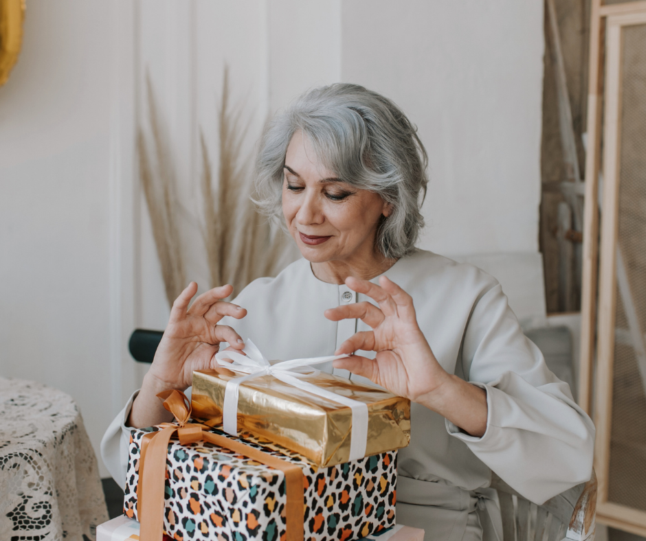 a woman ties a bow on a present