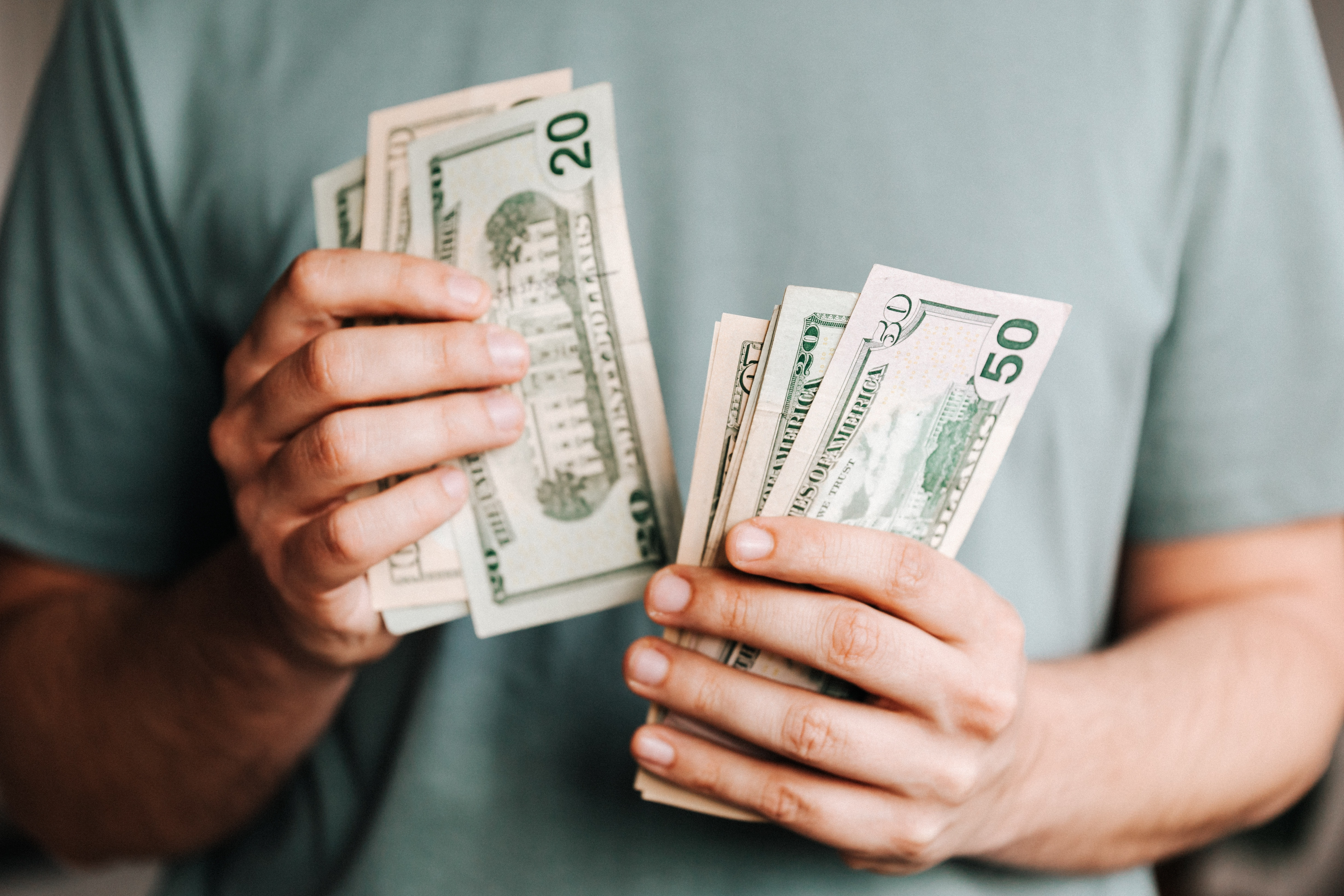 A cropped photo of a man counting dollars