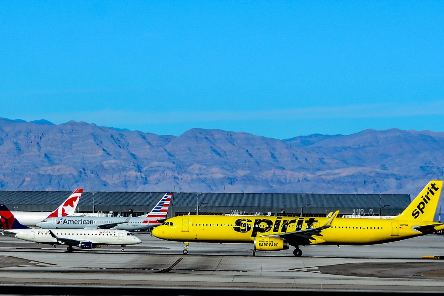 yellow colr spiritvairlines flight and white color american airlines flight at an airport