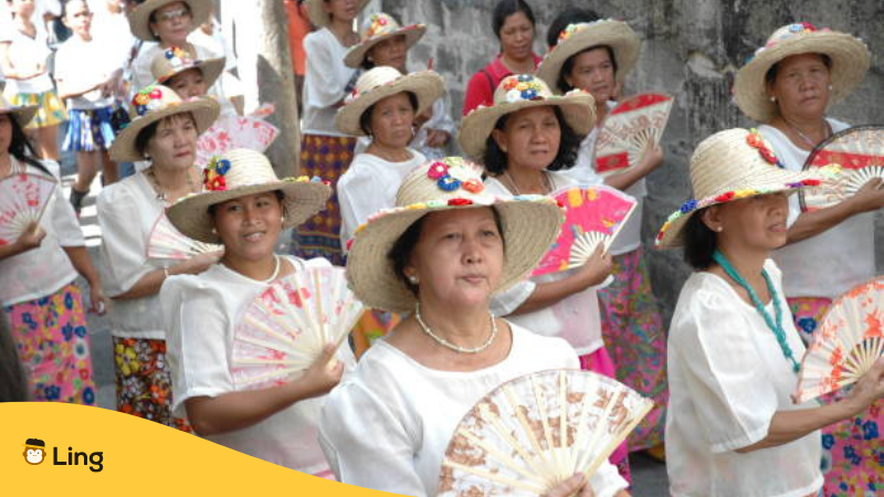 The women with traditional clothes and fan walking in street of Manila, Philippines during festival