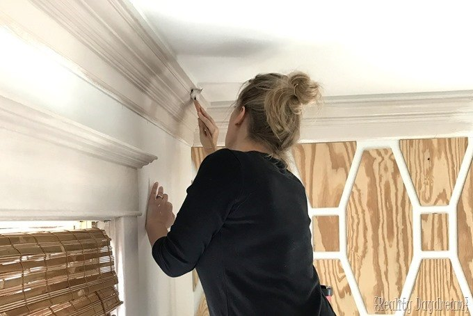 Photo of a girl painting corners of the ceiling