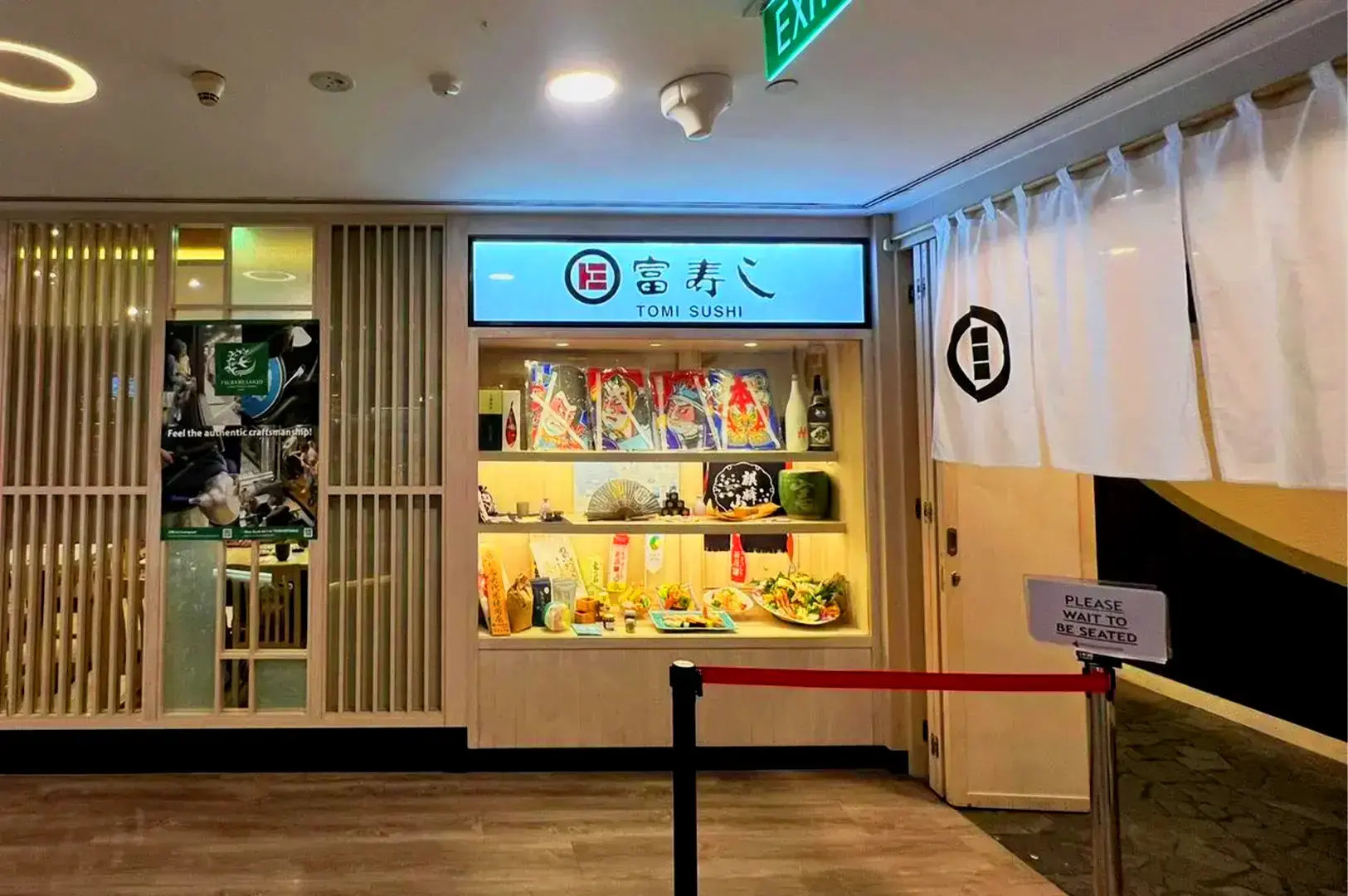 Tomi Sushi Singapore restaurant entrance with Japanese décor, sake display and traditional noren curtains