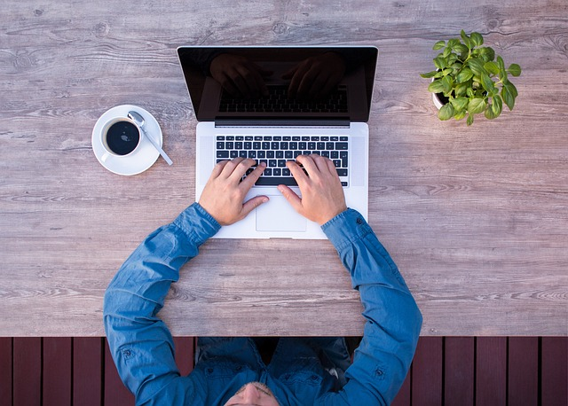 A person typing into a laptop.