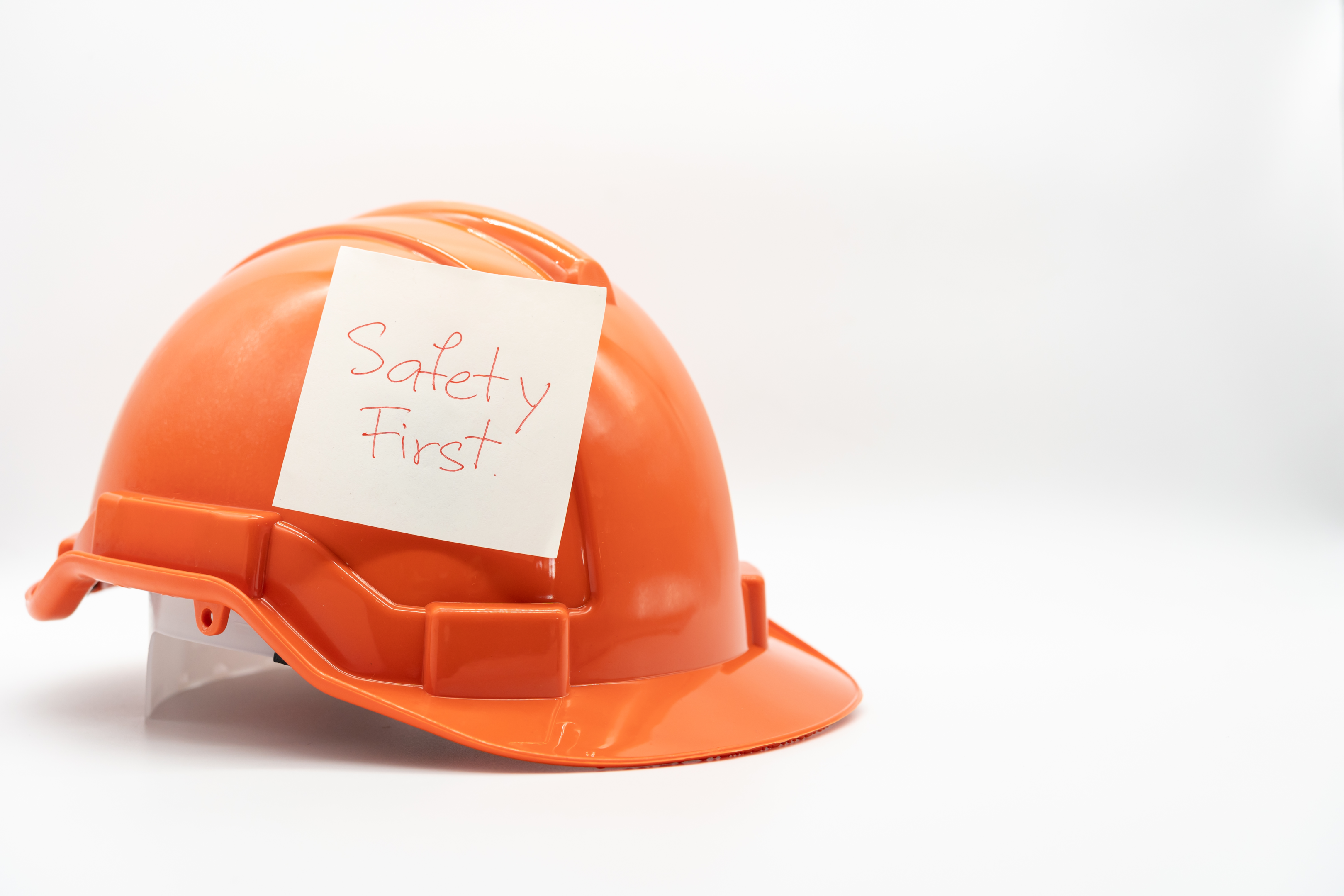 orange safety hat with "Safety First" message