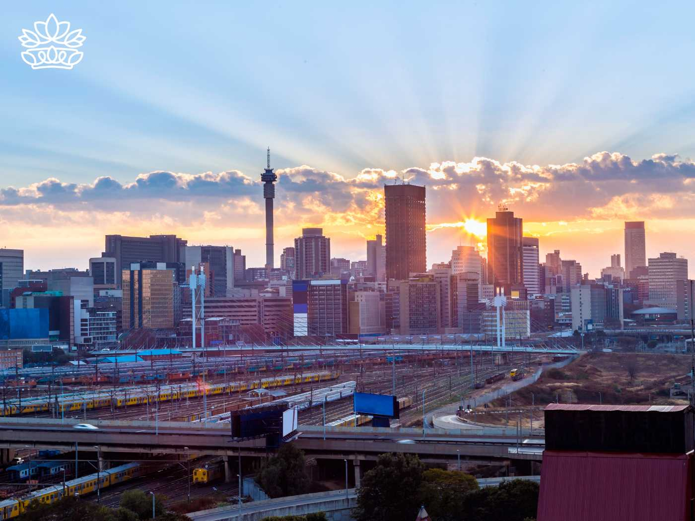 Radiant sunrise over the Johannesburg skyline, illustrating the city's dynamic energy and the promise of a new day. This cityscape is the backdrop for the Johannesburg Gift Delivery Collection, transforming ordinary moments into lovely occasions with birthday gifts, gift boxes, and hampers delivered right to your doorstep. Fabulous Flowers and Gifts.