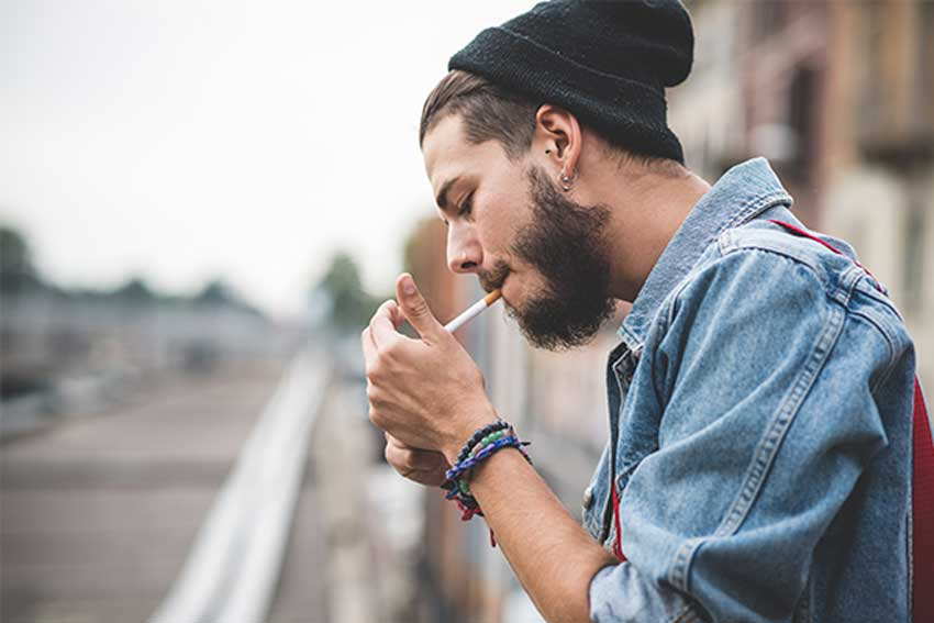 male smoking cigarette with beanie