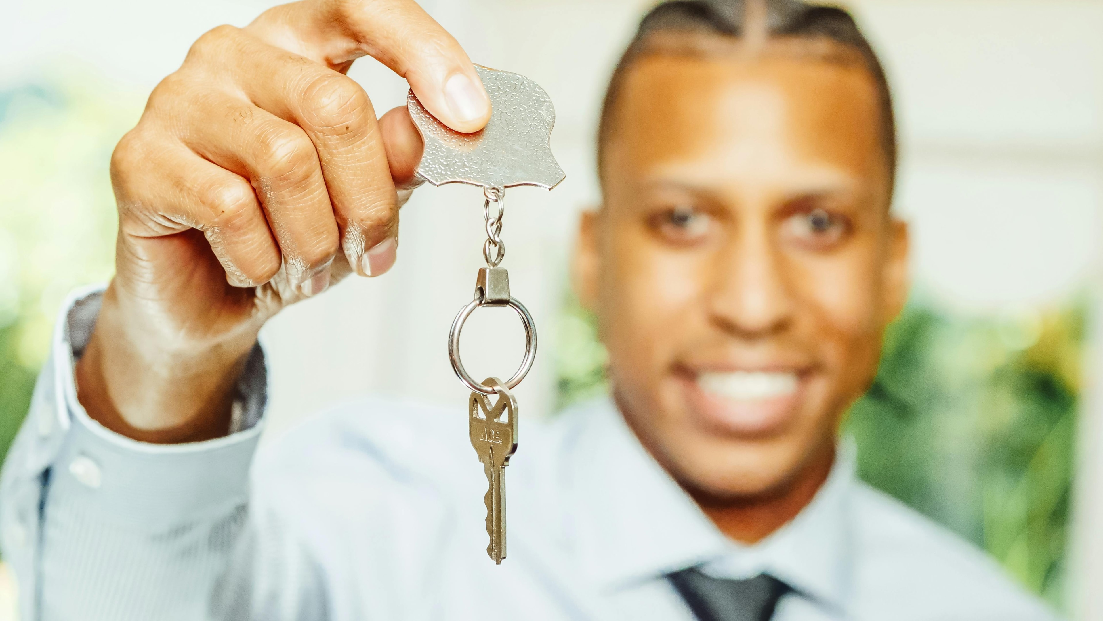 Real estate investor holds house key to single family house recently purchased to be used as affordable housing.