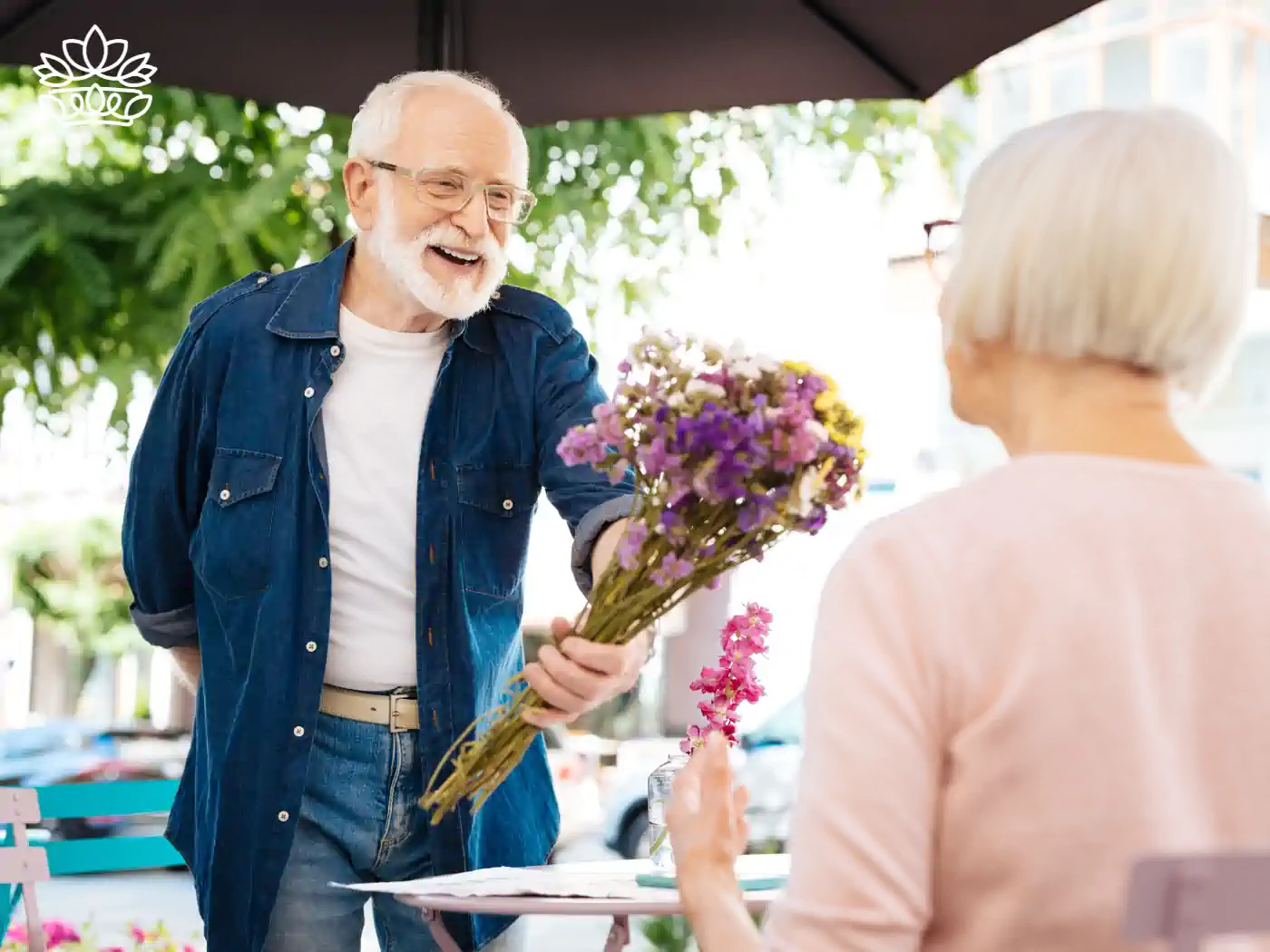 A touching scene of an elderly man presenting a bouquet of flowers to his wife, symbolizing enduring love and cherished memories. Fabulous Flowers and Gifts.
