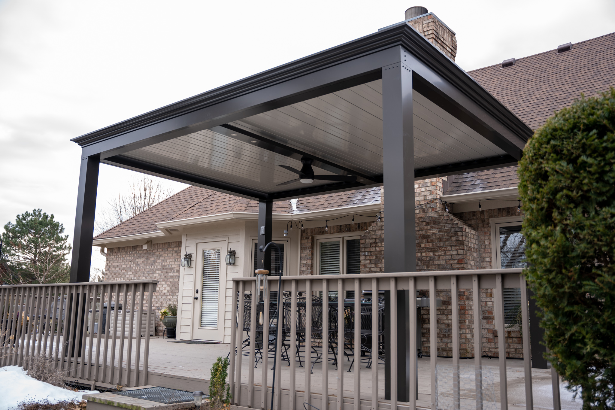 A deck pergola with seating area and climbing vines, creating a perfect outdoor dining area