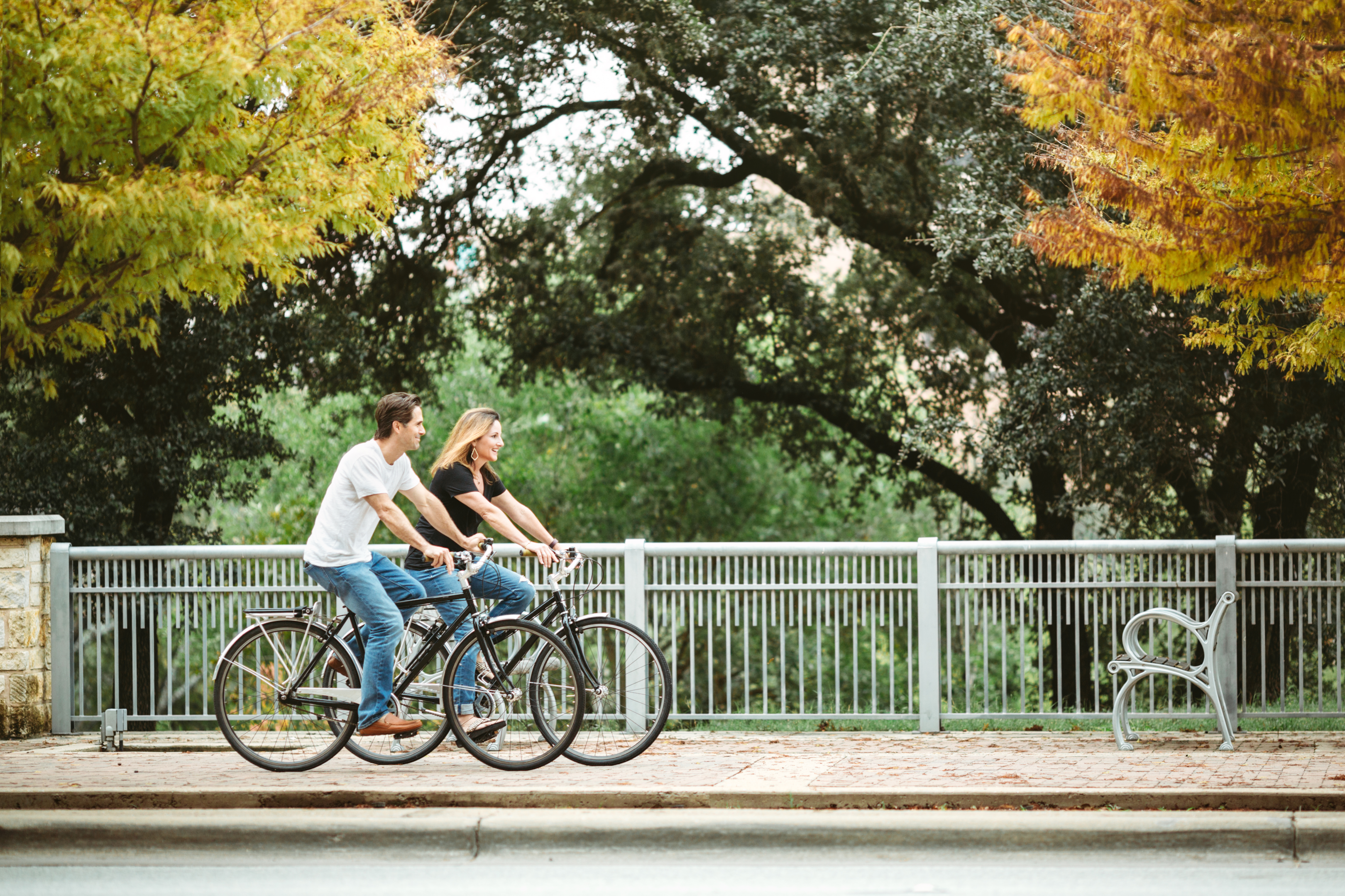 Couple riding on cruiser bikes around downtown in the fall