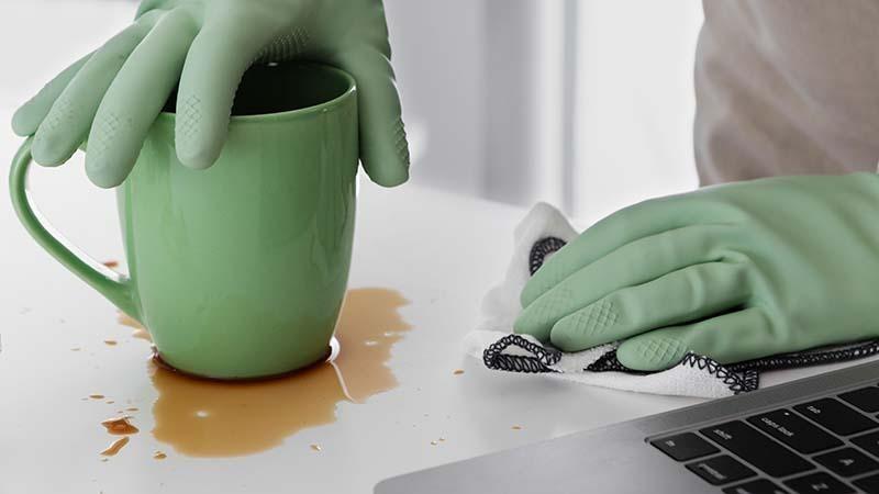 Cleaning a coffee spill with a microfiber cloth