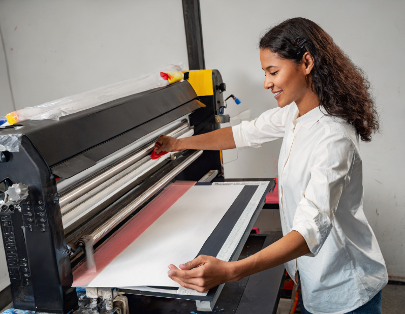 person with screen printing machine - what is screen printing - i love screen printing