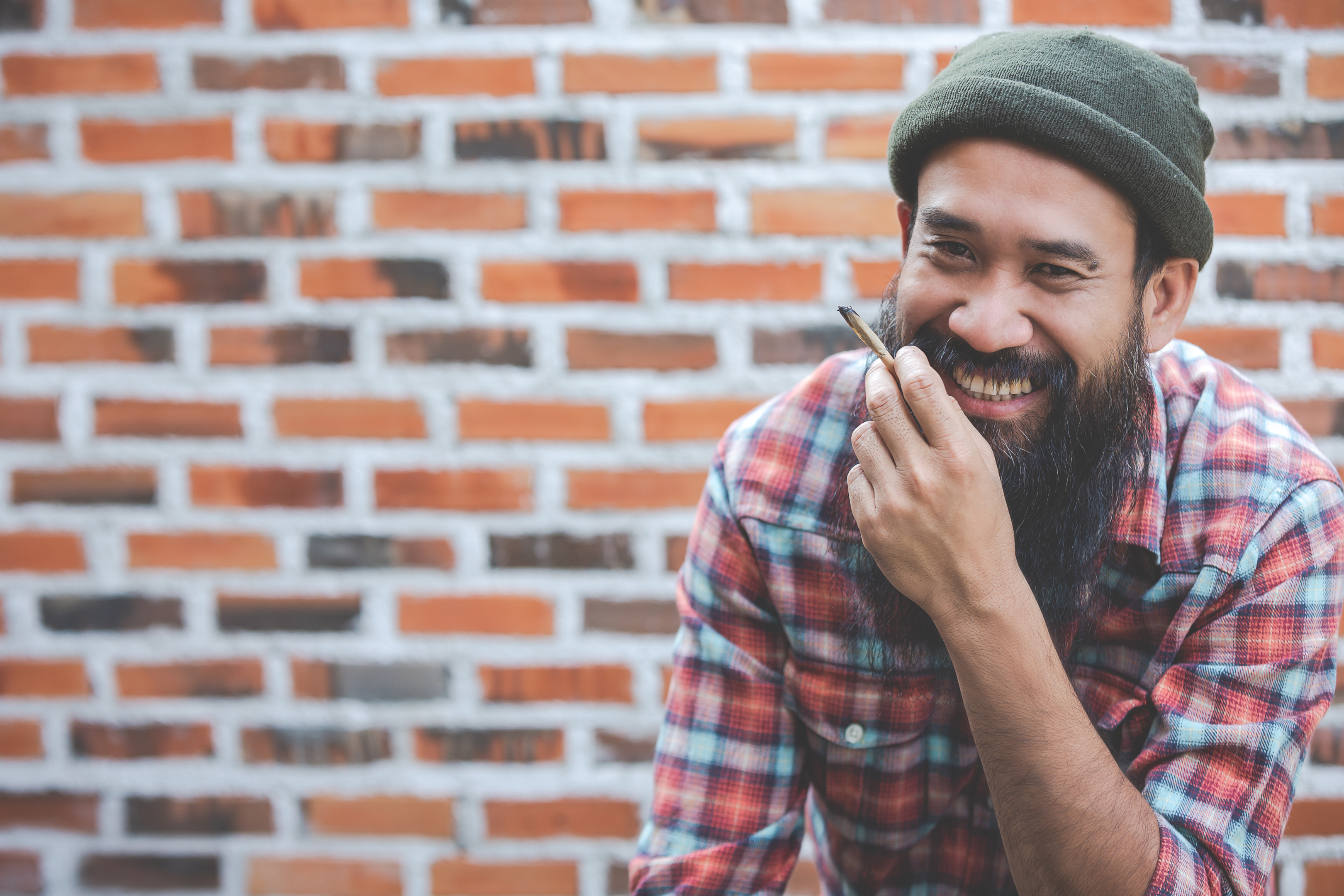 Person enjoying their hand rolled hemp/cannabis product. The plant needs more medical research on if it might help symptoms of issues with chronic pain, nausea, insomnia, as well as any potential negative effects.